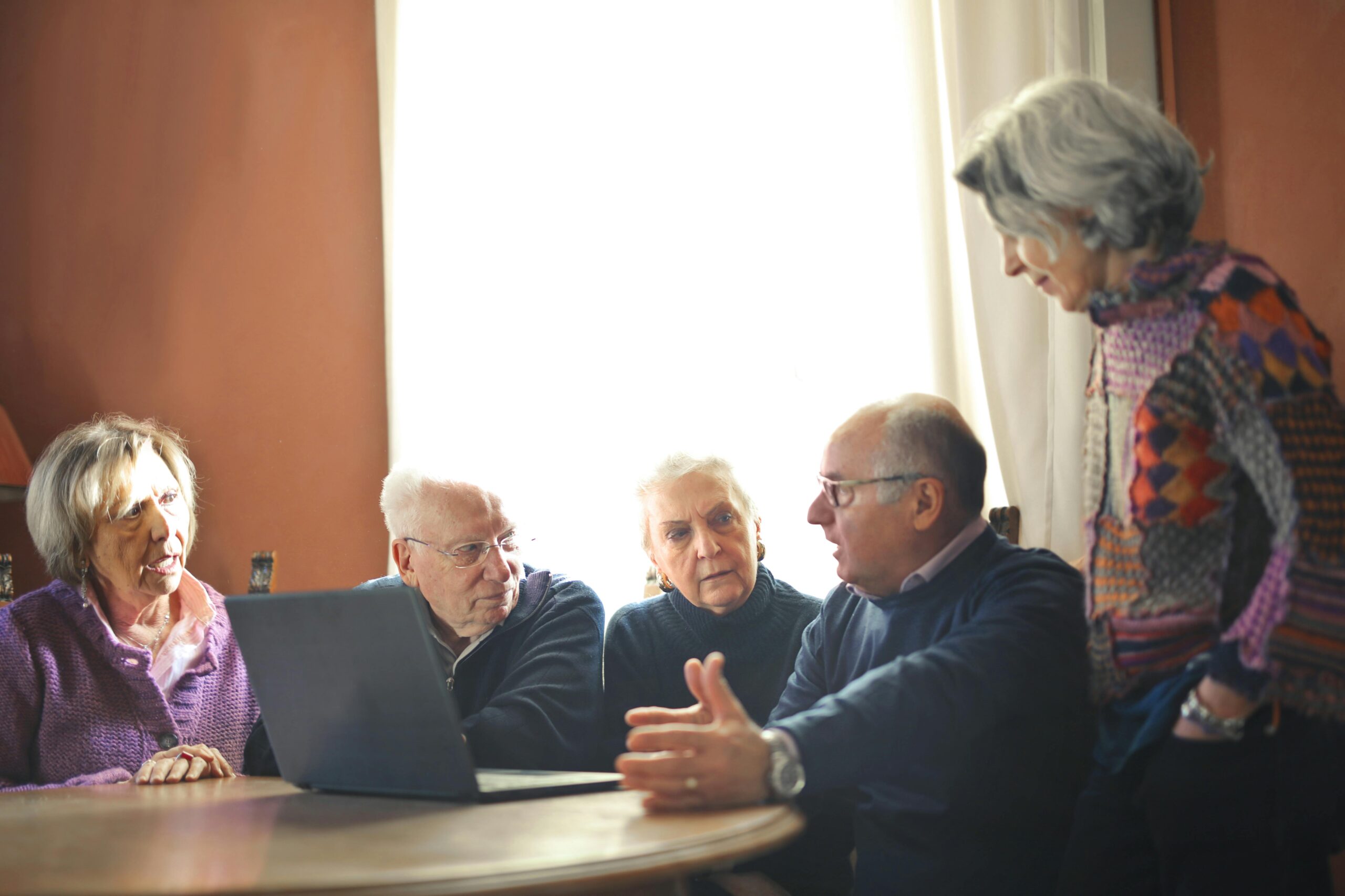 older adults having a conversation around a computer